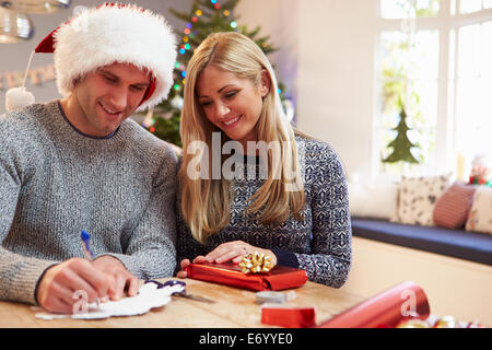 Couple Wrapping Christmas Gifts At Home Banque D'Images