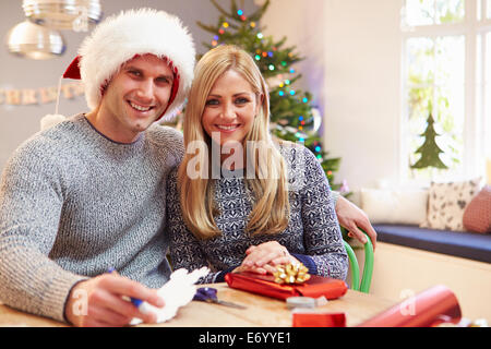 Couple Wrapping Christmas Gifts At Home Banque D'Images