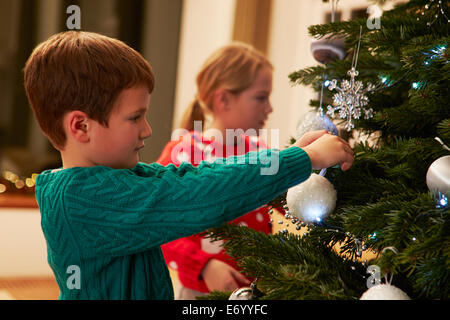 Les enfants à la maison de l'arbre de Noël Décoration Banque D'Images