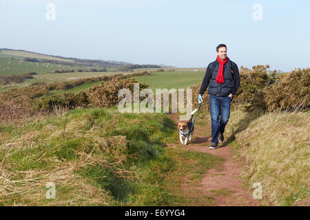 Homme avec chien à marcher le long du sentier côtier Banque D'Images