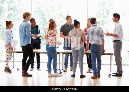 Avec les étudiants de collège enseignant par classe dans un bureau permanent Banque D'Images