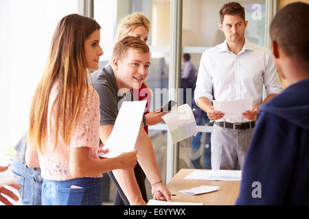 Avec les étudiants de collège enseignant par classe dans un bureau permanent Banque D'Images