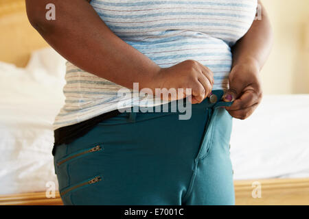 Close Up de l'excès de femme essayant de fixer le pantalon. Banque D'Images