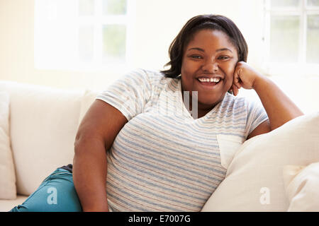 Portrait de l'excès de Woman Sitting on Sofa Banque D'Images