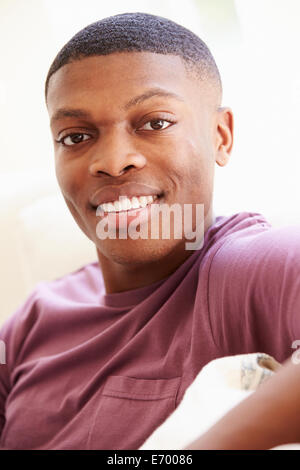 Portrait of Young Man Sitting on Sofa Banque D'Images