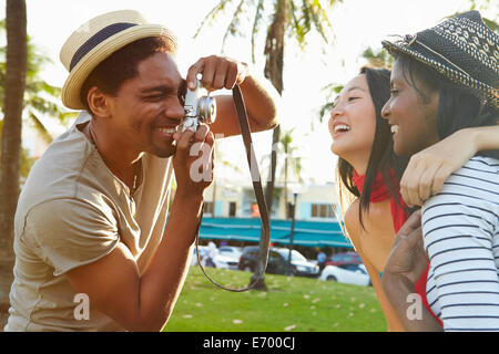 Man Taking Photograph des femmes dans Park Banque D'Images