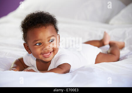 Mignon bébé couché sur le ventre dans le lit des parents Banque D'Images