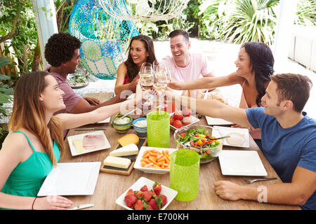 Group of Friends Enjoying Meal Outdoors At Home Banque D'Images