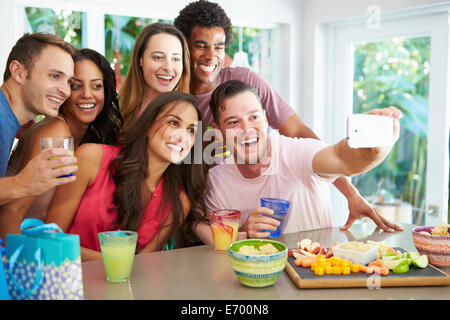 Groupe d'amis prenant tout en Selfies Celebrating Birthday Banque D'Images