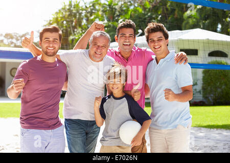 Homme Multi Generation Family Playing Volleyball dans jardin Banque D'Images