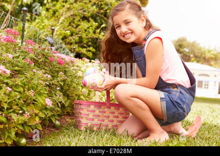 Girl Chasse aux Œufs de Pâques dans le jardin Banque D'Images