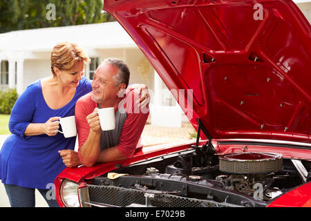 Couple avec voiture classique restauré Banque D'Images