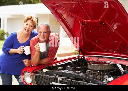 Couple avec voiture classique restauré Banque D'Images