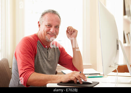 Portrait of Senior Man Using Computer At Home Banque D'Images