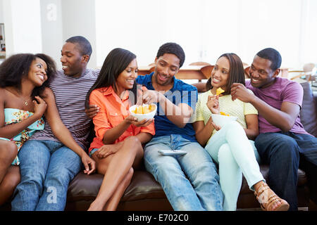 Groupe d'amis assis sur le canapé à regarder la télévision ensemble Banque D'Images