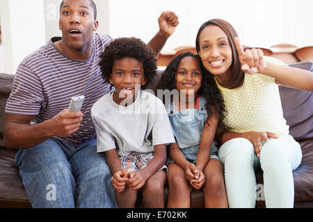 Family Sitting on Sofa à regarder la télévision ensemble Banque D'Images