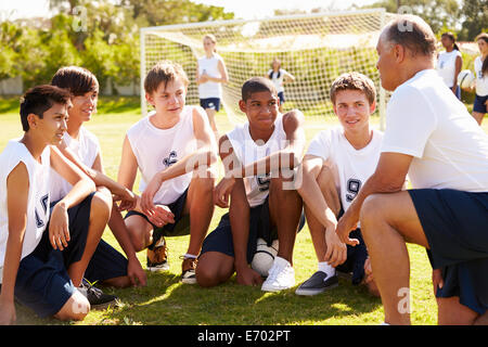 Coach de l'équipe donnant parler à l'équipe de soccer masculin High School Banque D'Images