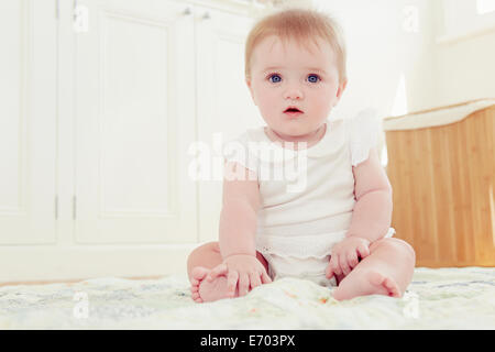 Portrait of baby girl sitting on floor Banque D'Images