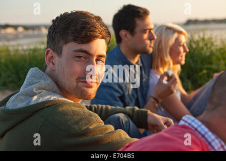 Quatre amis adultes assis sur la plage de Bournemouth, Dorset, UK Banque D'Images