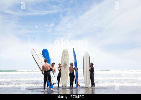 Groupe d'hommes et femmes d'amis surfer beach avec des planches de surf Banque D'Images