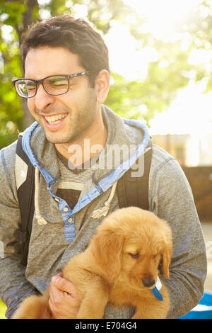 Young man holding labrador, chiot Banque D'Images