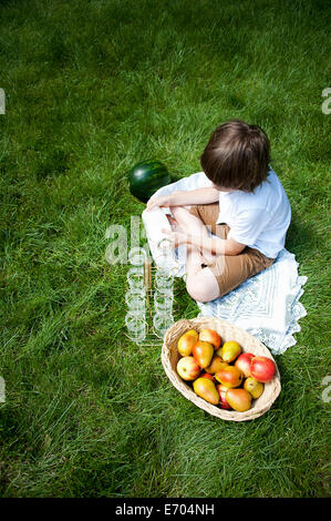 Vue de dessus de l'herbe vrksasana garçon verser dans des verres de lait Banque D'Images