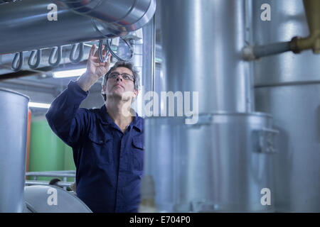 Engineer inspecting pipes in power station Banque D'Images