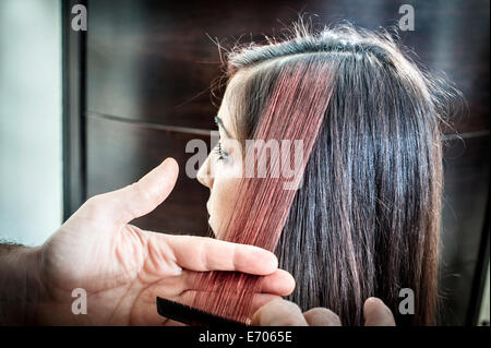 Coiffure homme peignant les cheveux de la jeune femme dans un salon de coiffure Banque D'Images