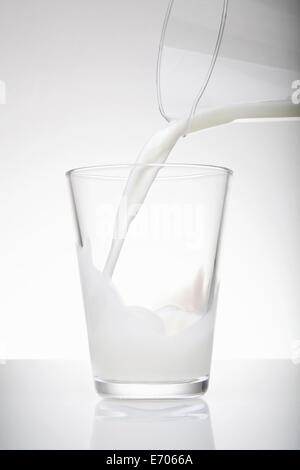 Verser le lait frais à partir de la verseuse en verre Banque D'Images