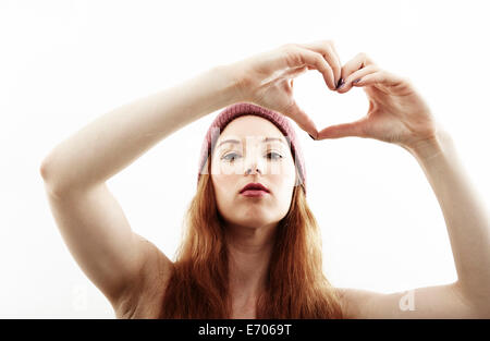 Studio portrait of young woman making heart shape with hands Banque D'Images