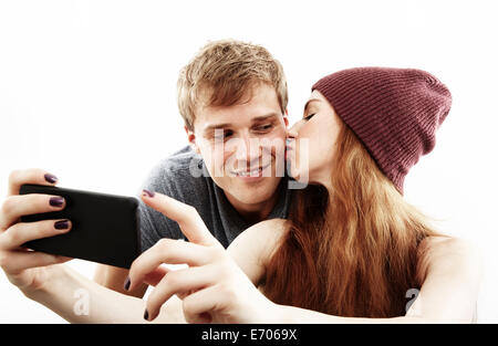 Studio portrait of young couple sur smartphone selfies Banque D'Images