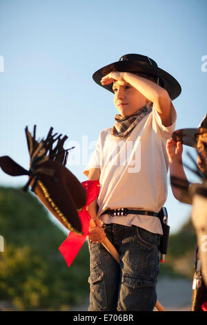 Deux garçons habillés comme des cowboys sur dadas Banque D'Images