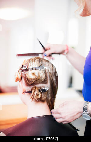 Femme avec les cheveux dans les cheveux dans le salon Banque D'Images