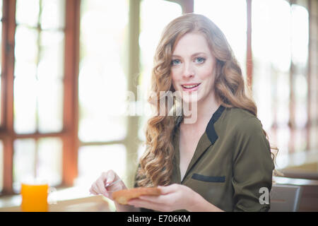 Jeune femme assise au restaurant table avec tranche de pain grillée Banque D'Images