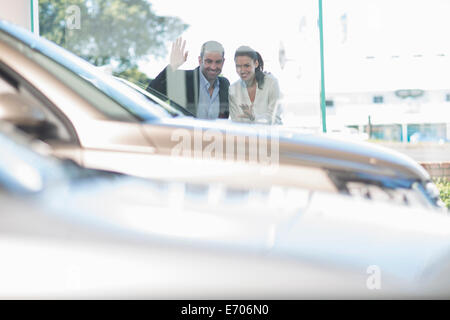 Couple à la fenêtre grâce à l'agence de voiture Banque D'Images