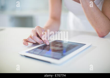 Close up of young womans hand using digital tablet écran tactile de comptoir de cuisine Banque D'Images