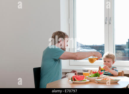 Le père et le petit garçon le petit-déjeuner à table de cuisine Banque D'Images