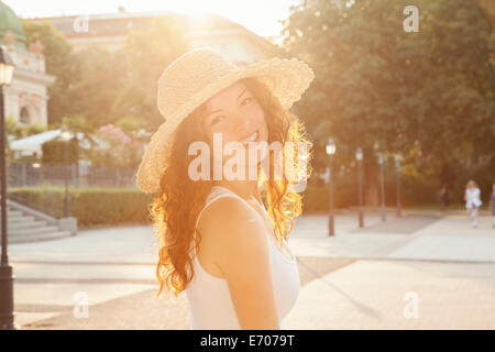 Portrait de jeune femme à la Par-dessus son épaule en ville Banque D'Images