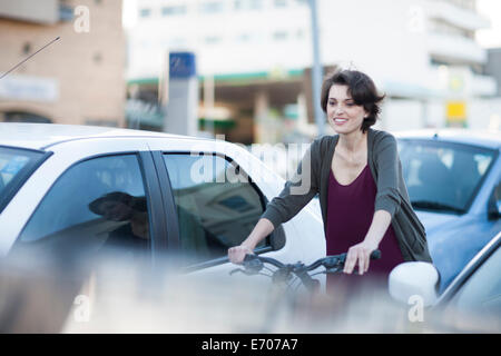 Les jeunes cyclistes de sexe féminin par la navette city traffic jam Banque D'Images