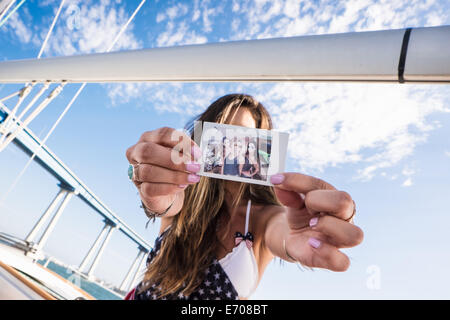 Young woman holding photo en face de visage Banque D'Images