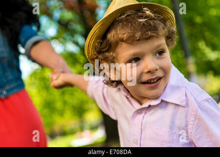 Close up of boy holding mother's hand in park Banque D'Images