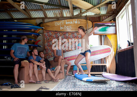 Cinq jeunes amis surfeur adultes fricoter dans hangar surf Banque D'Images
