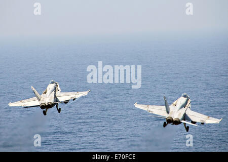 US Navy deux F/A-18C Hornet décollant de l'envol du porte-avions USS George H. W. Août 30, 2014 Bush dans le golfe Persique. Les pilotes volent des frappes aériennes ciblées contre les extrémistes connus sous le nom de l'État islamique en Irak et au Levant. Banque D'Images