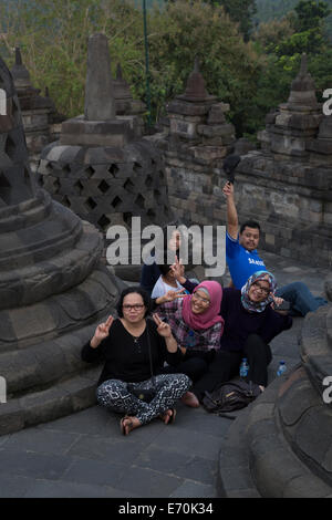 Borobudur, à Java, en Indonésie. La famille indonésienne qui pose pour la photo entre deux stupas. Banque D'Images