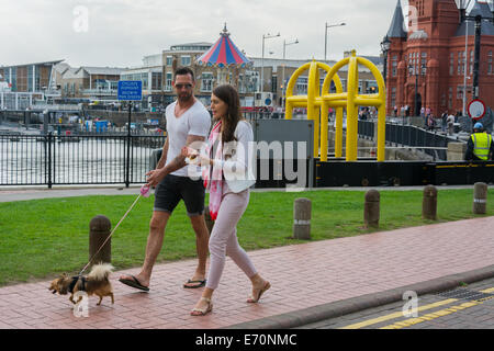 Cardiff, Royaume-Uni. 2Nd Sep 2014. Un couple en train de marcher leur chien dans la baie de Cardiff, en face de barrières de sécurité érigé pour le sommet de l'OTAN. La force de police font partie d'une vaste opération de sécurité pour le sommet de l'OTAN au Celtic Manor, Newport. C'est le premier sommet de l'OTAN au Royaume-Uni depuis 1990. Les dirigeants de 60 pays du monde entier sont attendus. Credit : Owain Thomas/Alamy Live News Banque D'Images