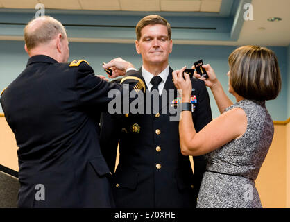 US Joint Chiefs Président Général Martin Dempsey et Michele Votel broche sur 4 étoiles revers sur son mari le général de l'Armée de Joseph L. Votel au cours de sa cérémonie de promotion à la tête du commandement des opérations spéciales, 28 août 2014 à Tampa, en Floride. Votel remplace sa retraite U.S. Navy Adm. William H. McRaven. Banque D'Images