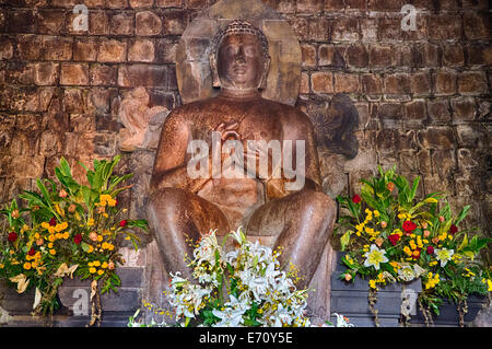 Borobudur, à Java, en Indonésie. Mendut Temple Bouddhiste. Dhyani Buddha statue, dans le geste (mudra) de Dharmachakra. Banque D'Images