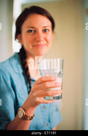 Une femme tenant un grand verre d'eau. Banque D'Images