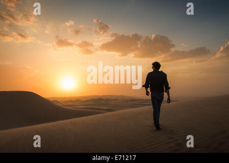 Homme marchant dans le désert, les dunes de sable de Glamis, California, USA Banque D'Images