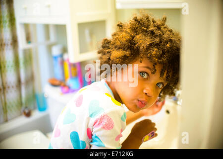 Portrait de jeune fille le rinçage de la bouche dans la salle de bains Banque D'Images